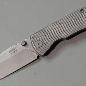 A sleek folding knife with a textured handle and partially open blade.