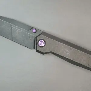 A modern, sleek folding knife with a metallic finish and purple accents.