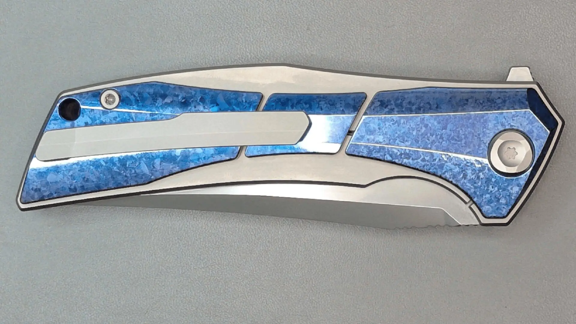A sleek, modern knife with blue stone inlays on the handle.