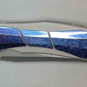 Close-up of a metallic and blue folding knife blade.