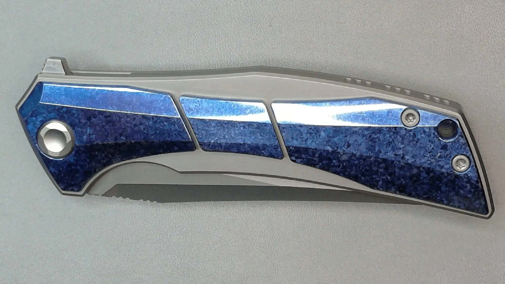 Close-up of a metallic and blue folding knife blade.