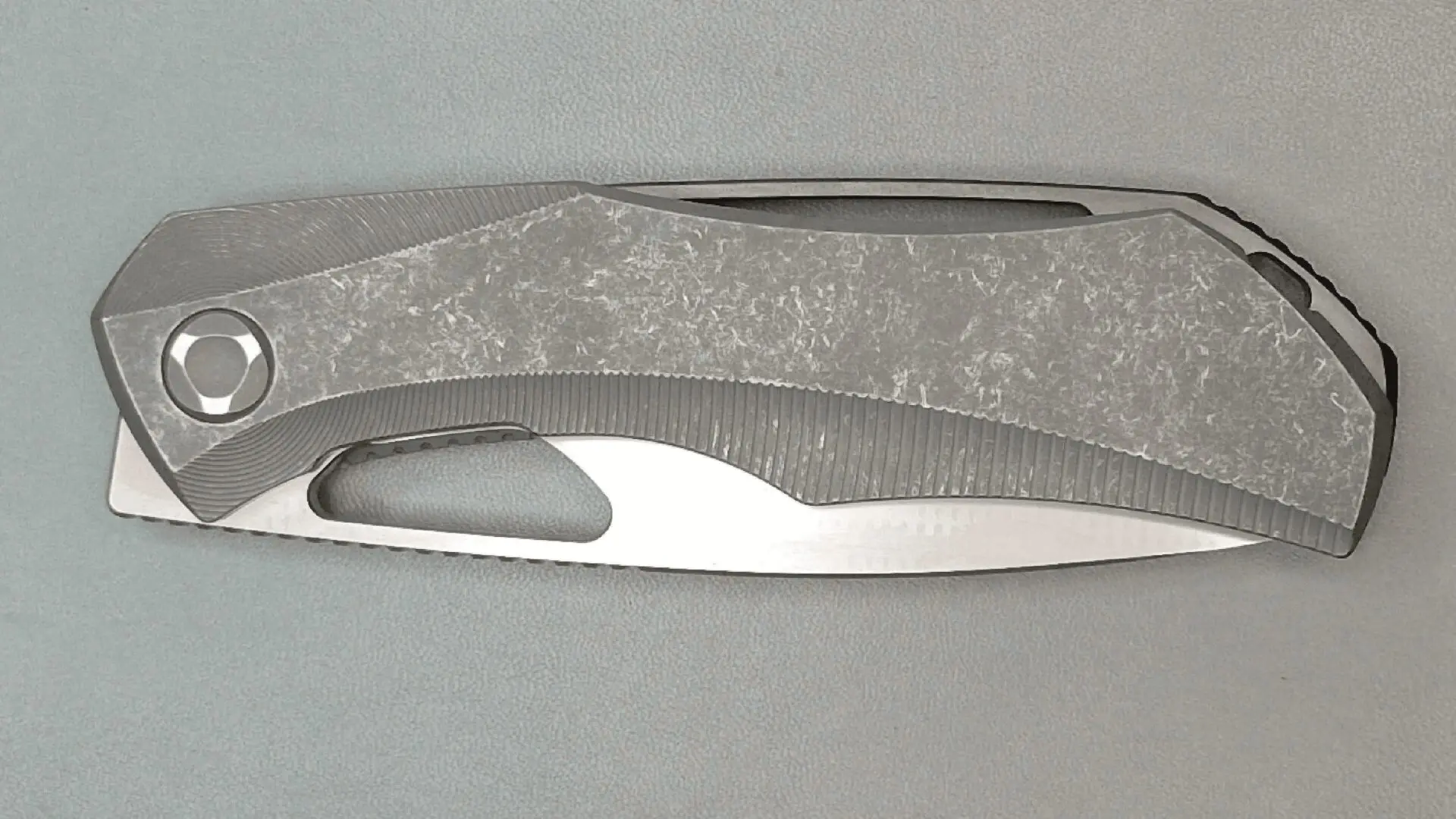 A metallic object with a sleek, curved design on a gray surface.