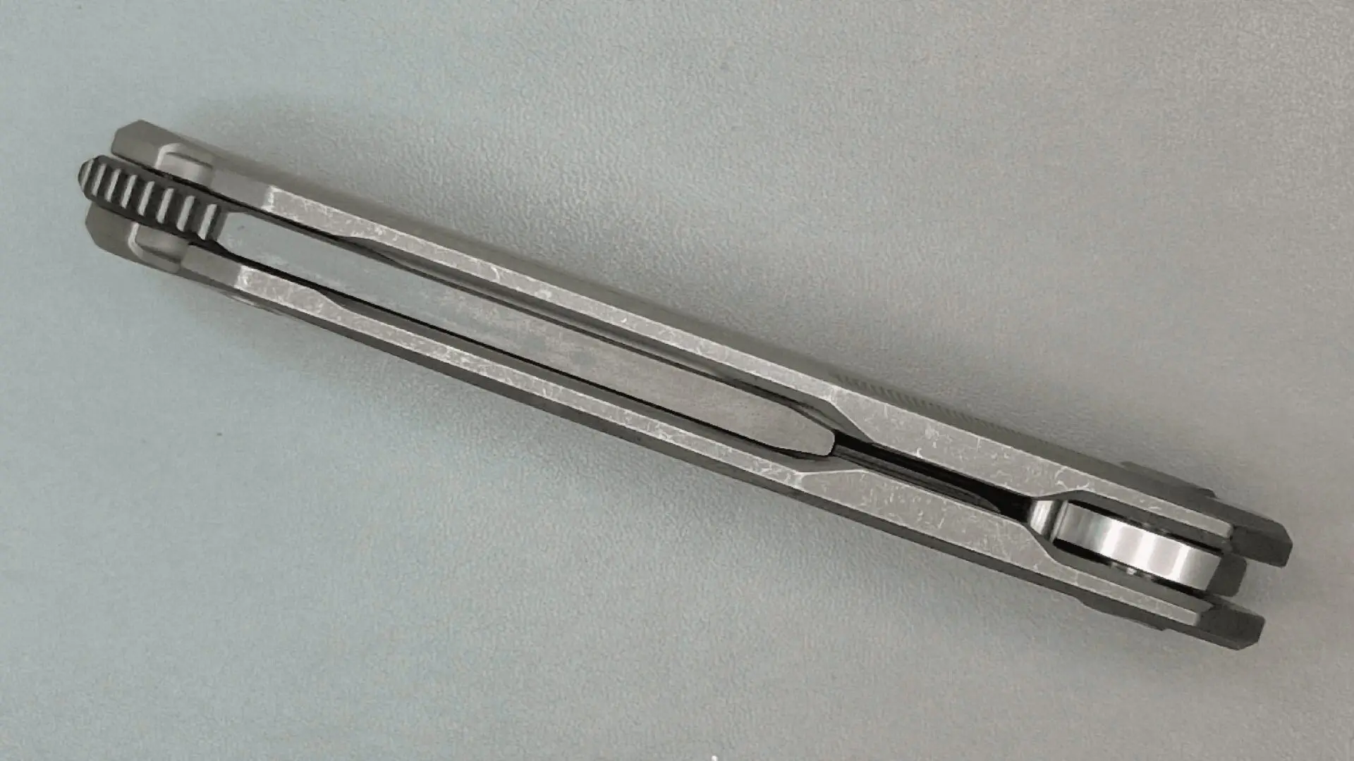 Close-up of a metal tuning fork on a gray surface.