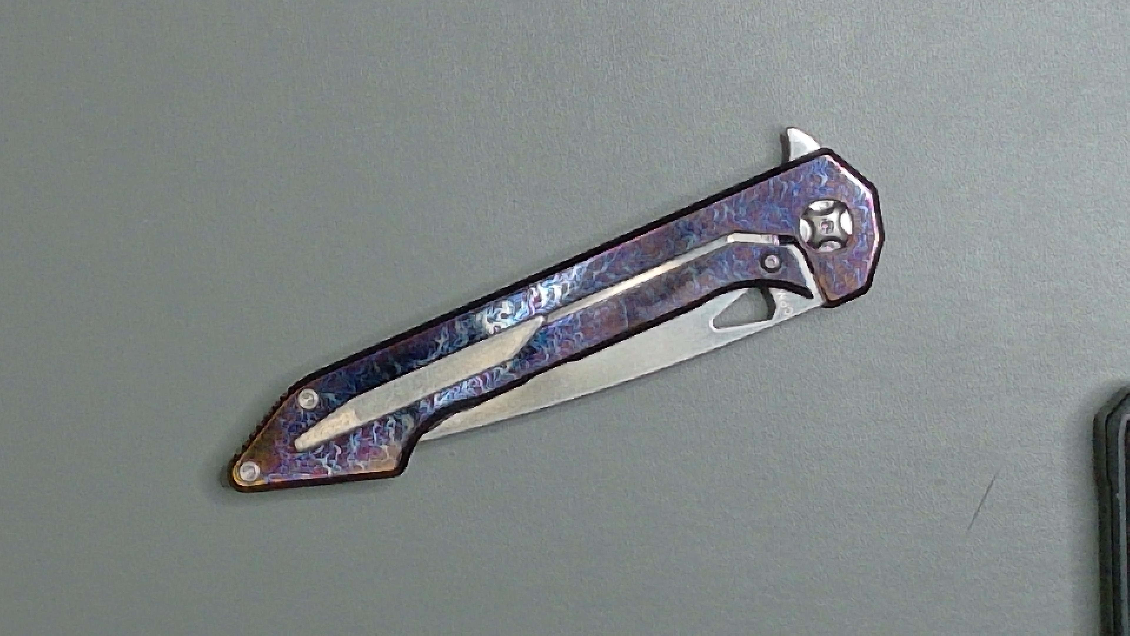 Folded pocket knife with a sleek handle and partially visible blade.