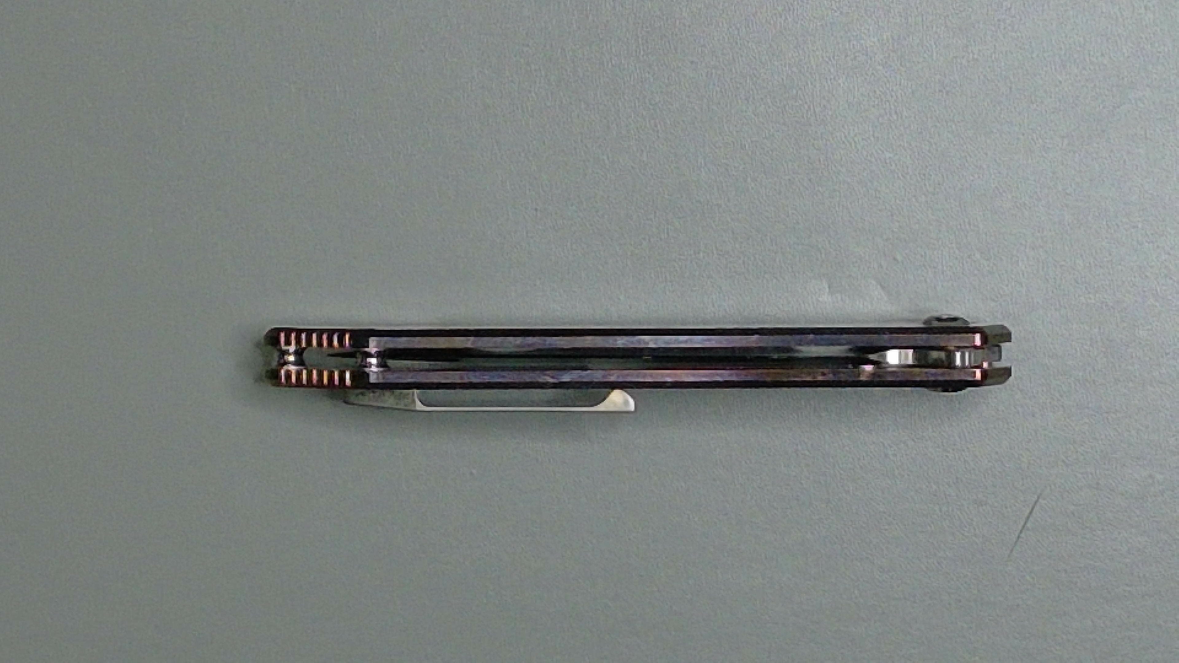 Two black pens placed horizontally on a grey surface.