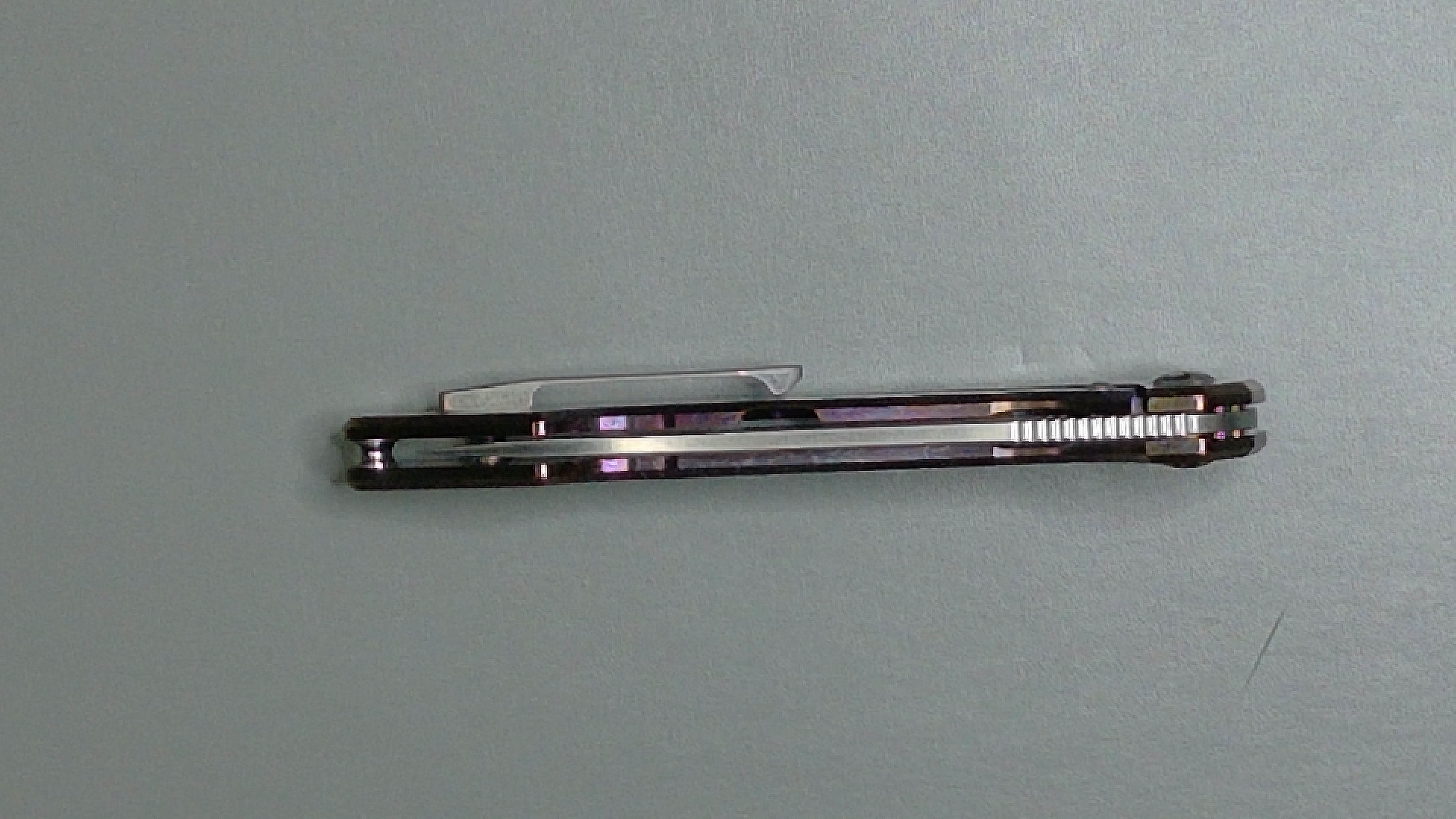 Two black pens placed on a gray surface.
