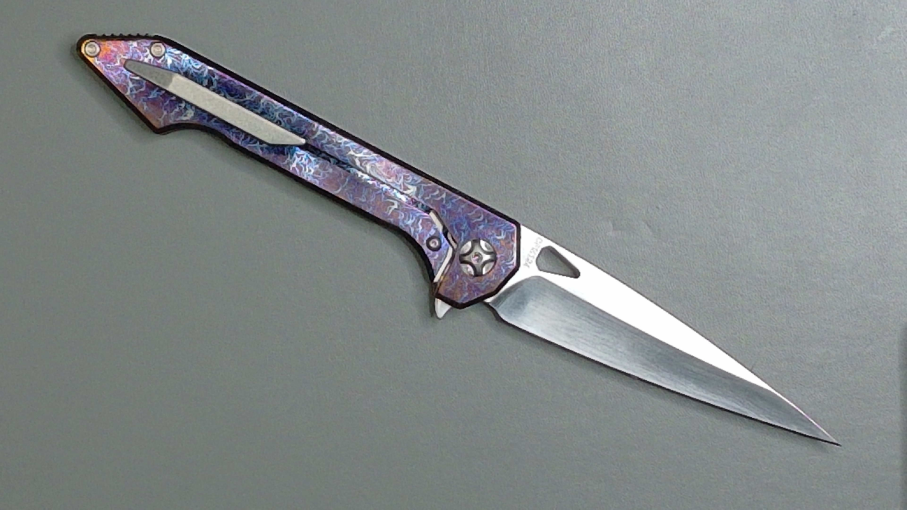A sleek folding knife with a purple handle and sharp blade.