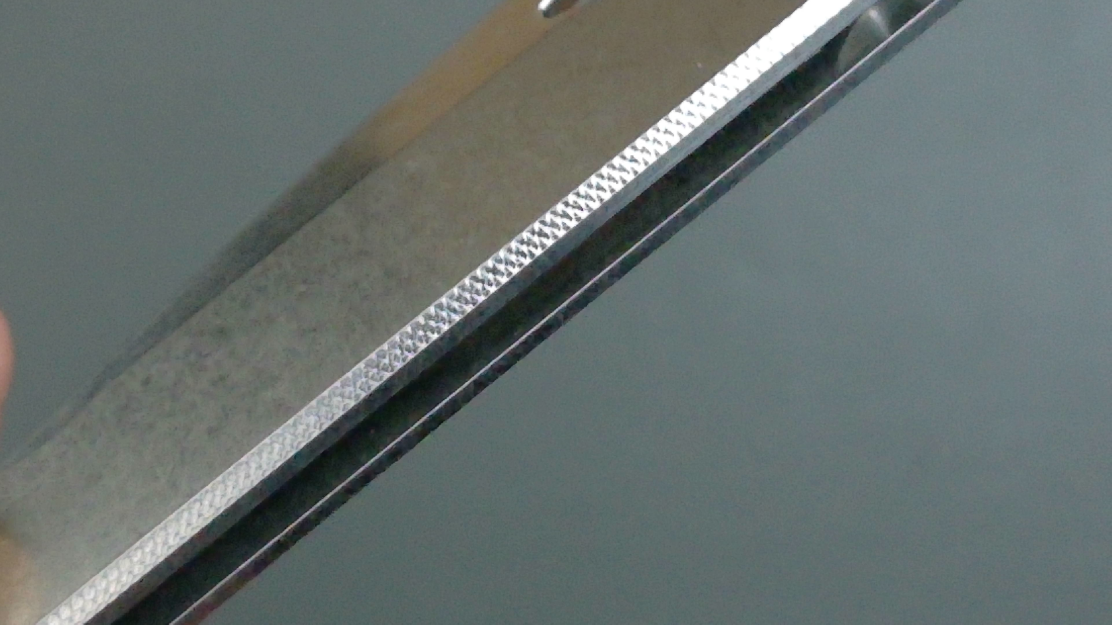 Close-up of a metallic blade with intricate patterns.