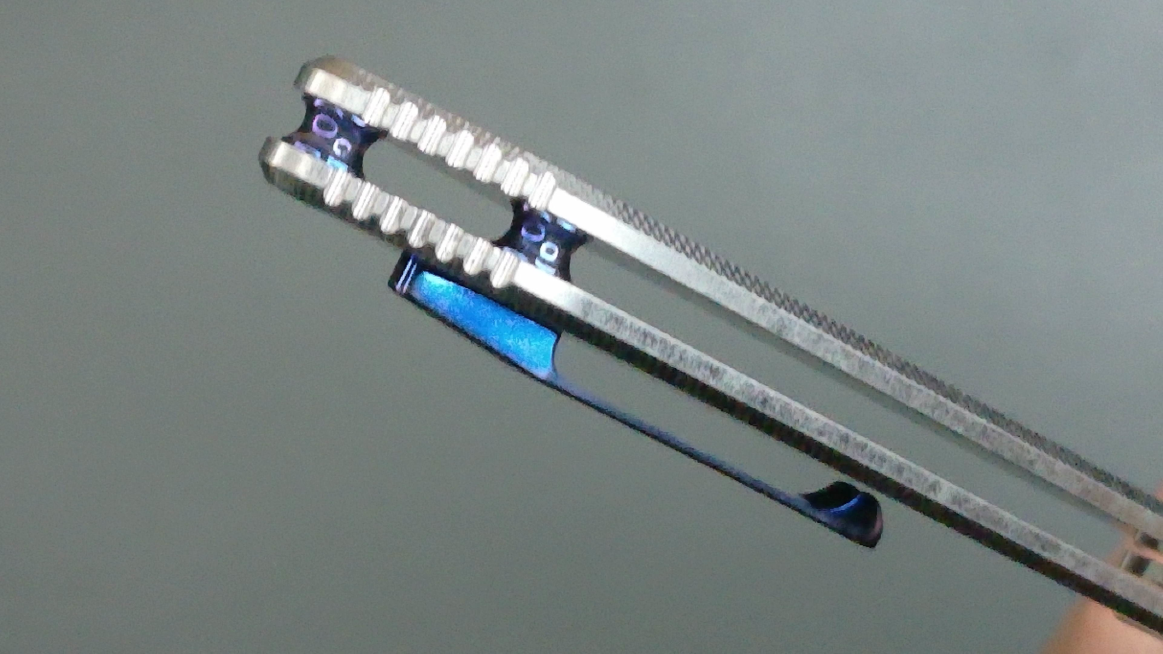 Two metallic hair clips with blue and white accents.