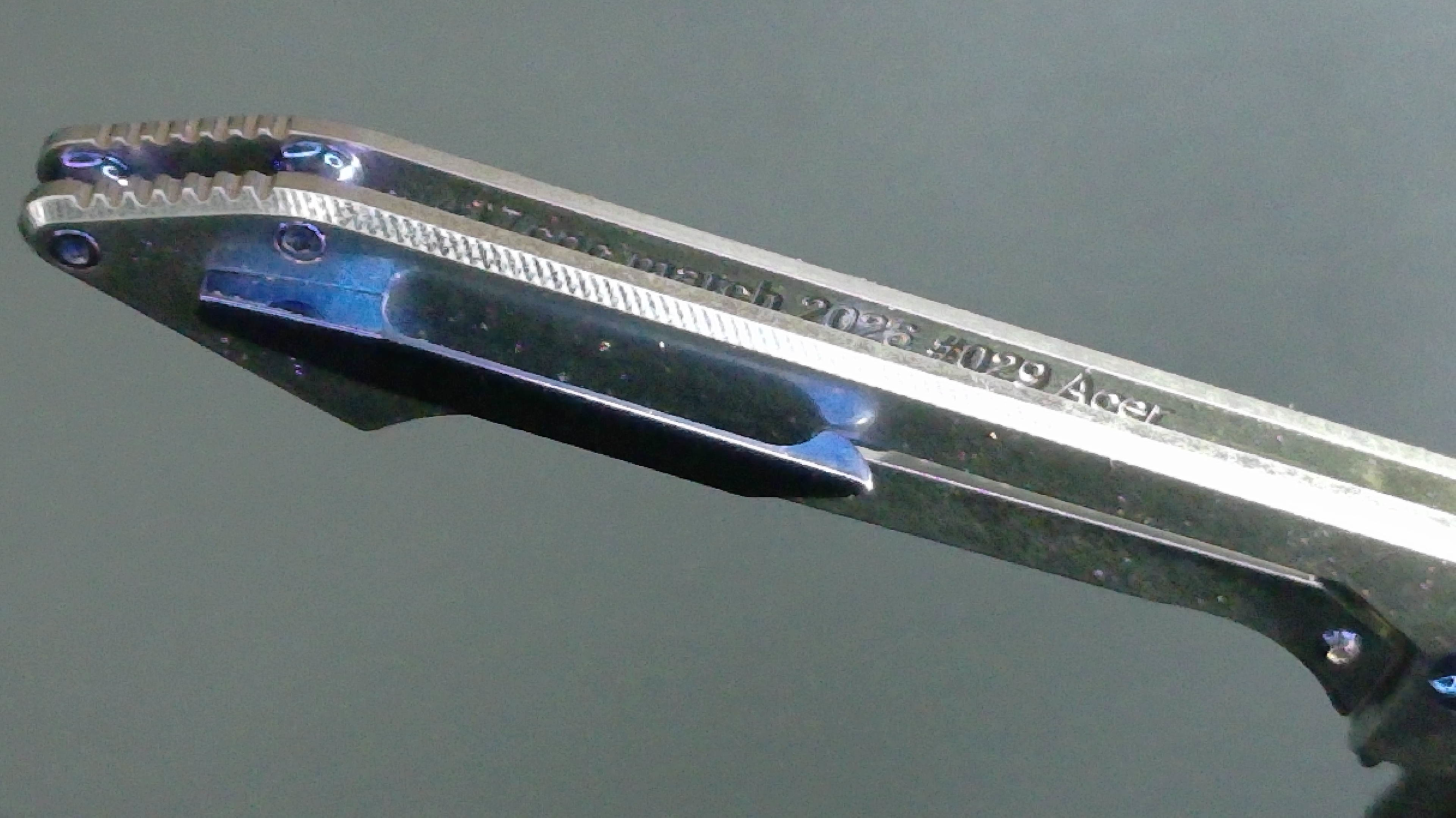 Close-up of a metal key blade with engraved text on its side.
