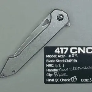 A silver folding knife with a metal handle on a textured surface.