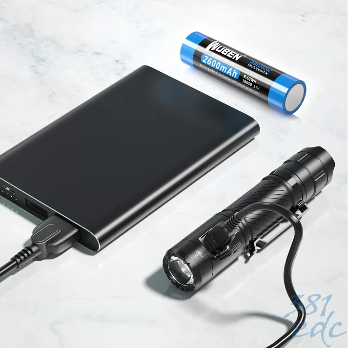 Wuben C3 flashlight with included 2600mAh 18650 battery and USB-C charging cable on marble surface